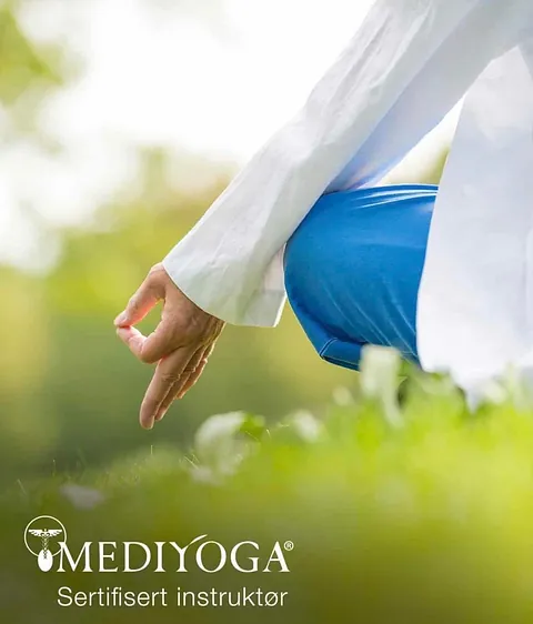 Person sitter i meditasjonsstilling utendørs som del av praksis innen MediYoga og avspenning.